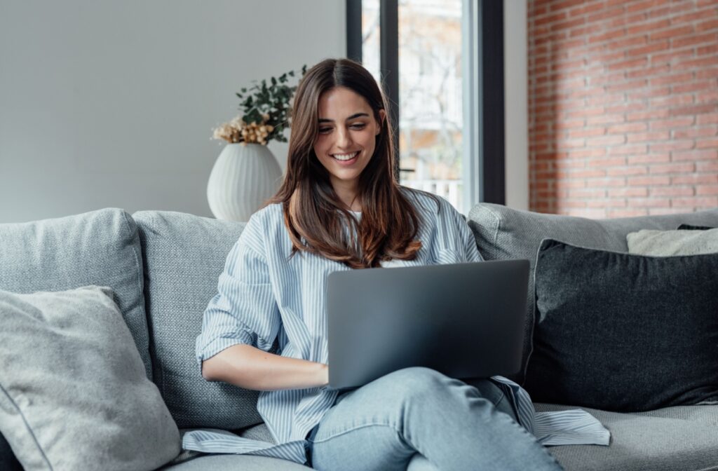 A person sitting on their couch with a laptop placing an order.
