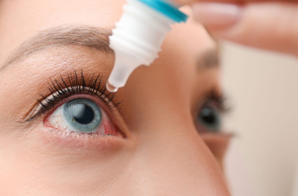 A person using eye drops to help soothe dry eye symptoms.